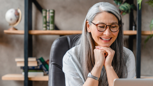 woman smiling in front of computer